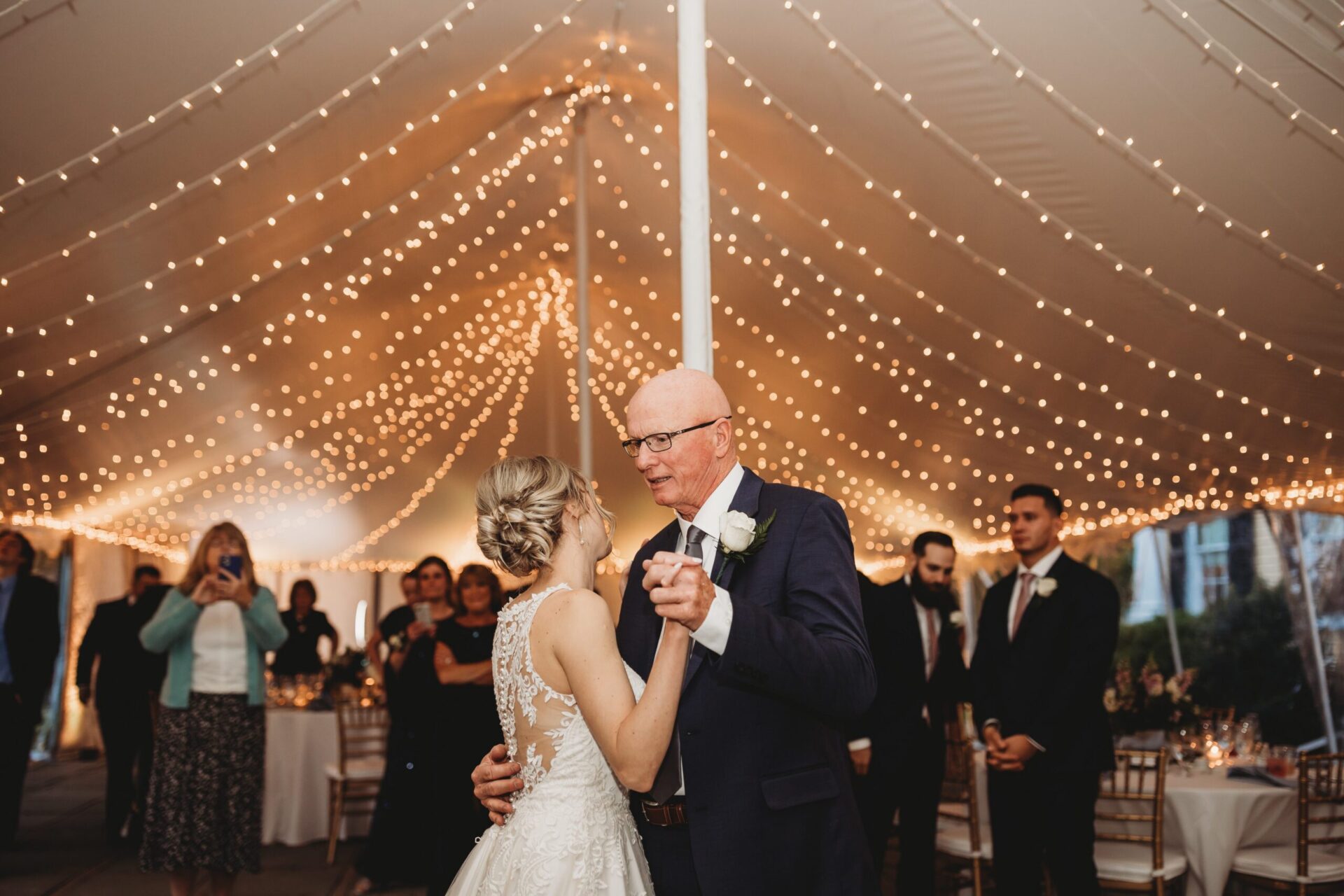 Warm Edison string bistro lighting hung at an outdoor wedding reception