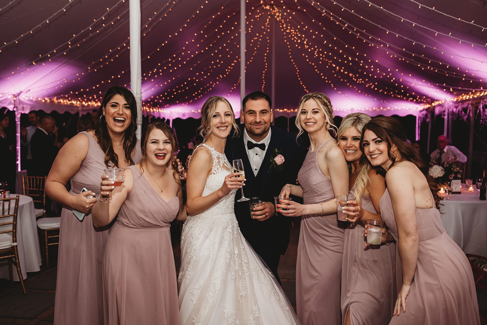 Wedding reception tent with bistro string lights and pink LED uplighting at Pierce House in Massachusetts