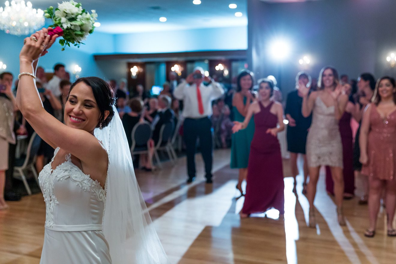 Bride bouquet toss at New England wedding photographed by Nick Grace