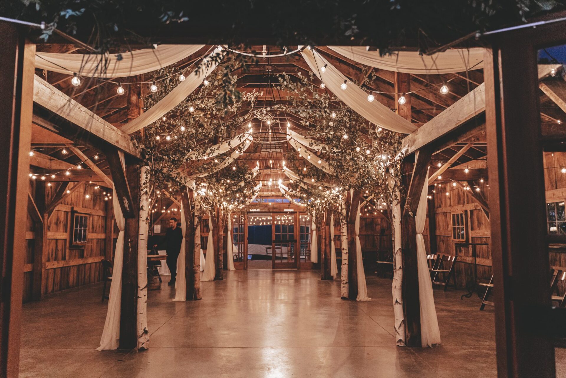 Rustic barn wedding venue at night with overhead bistro canopy lighting in New England