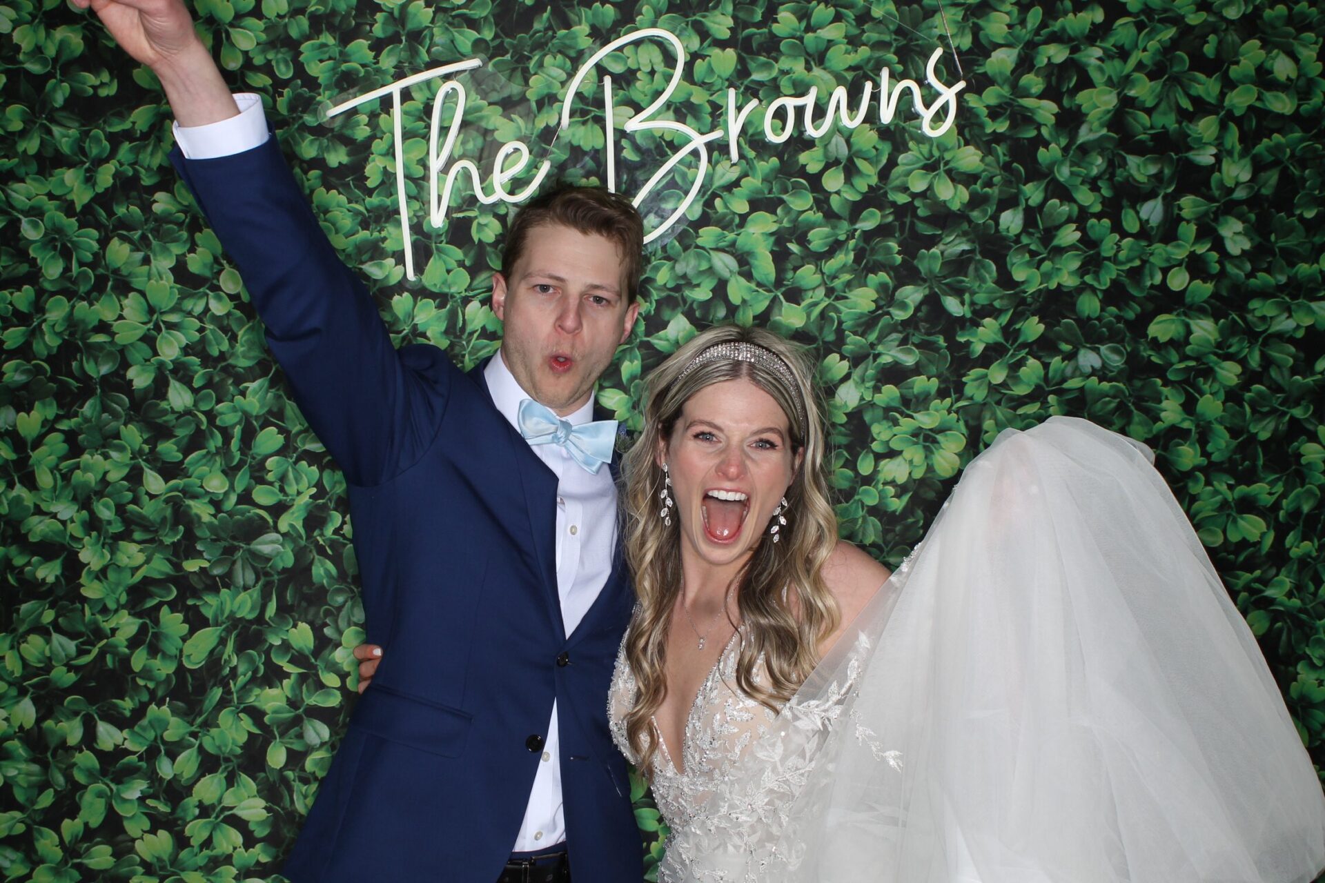 Custom neon sign mounted on a hedge wall at a wedding