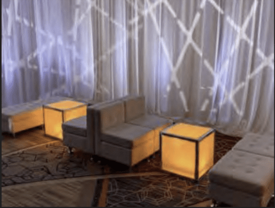 White VIP lounge seating pod with accent pillows at a New England wedding reception