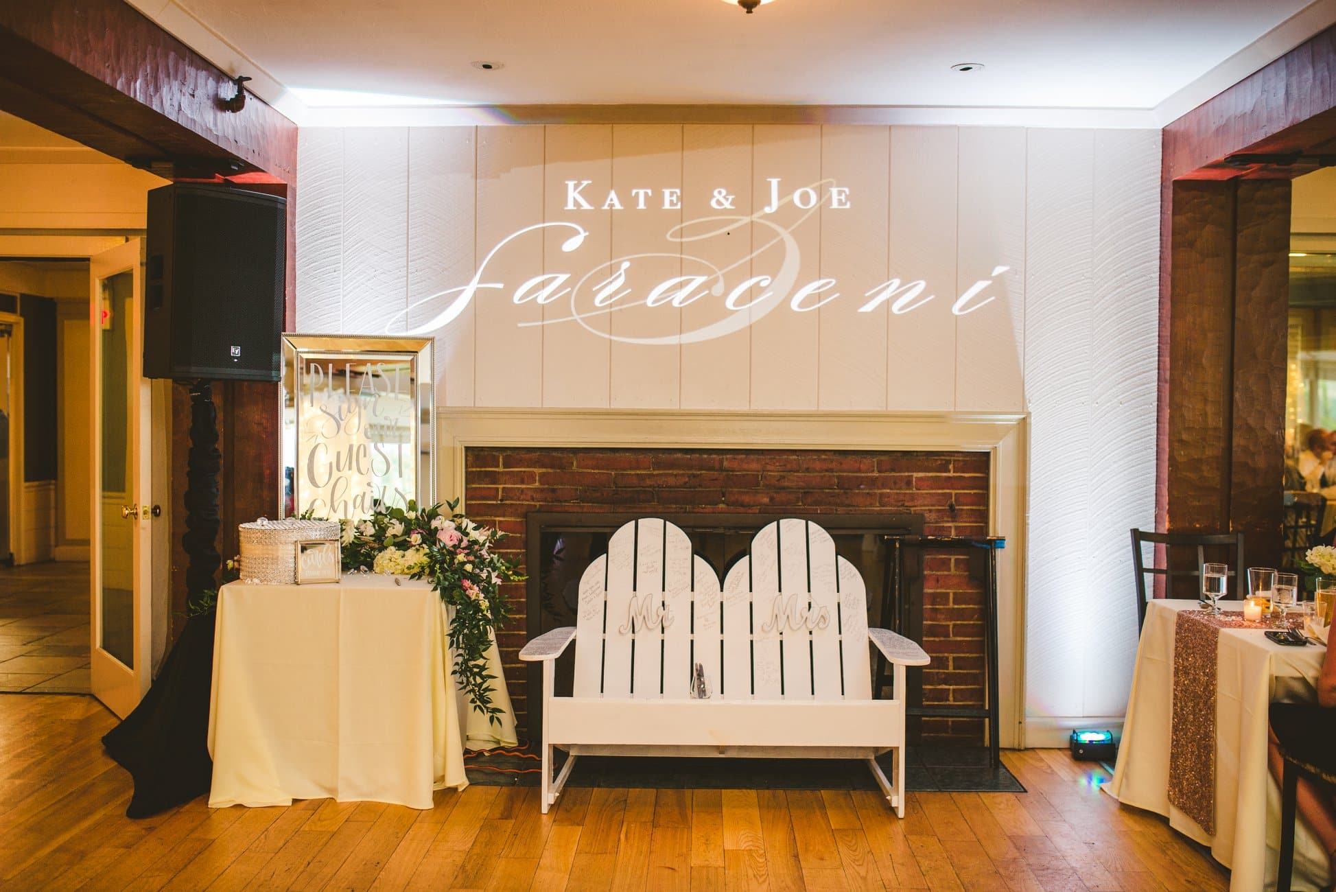 Custom couple monogram projected in warm gold light onto a wall at a New Hampshire wedding reception
