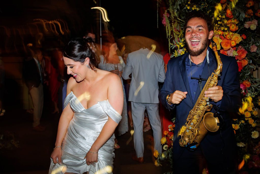 Wedding guests celebrating on dance floor during live saxophone and DJ performance at New England wedding reception
