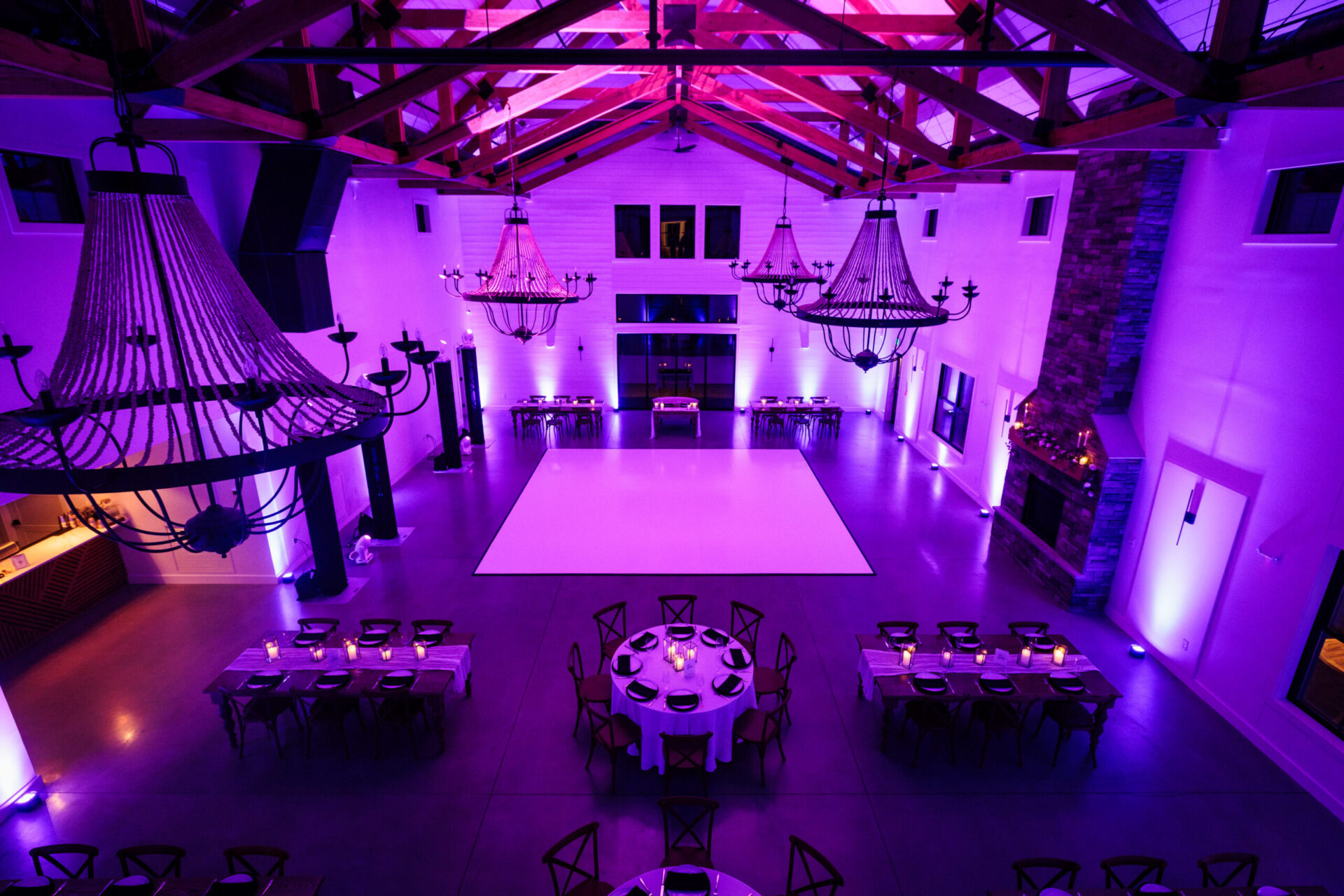 Glossy white dance floor rental at an elegant Boston wedding with vibrant purple uplighting