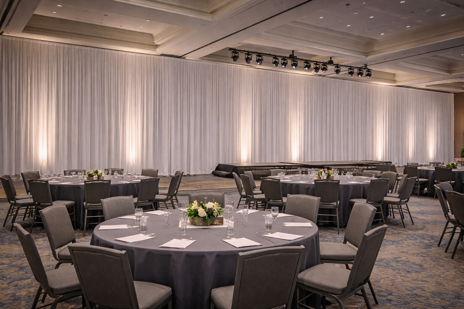 Stage backdrop pipe and drape installation paired with front wash lighting for a Boston corporate meeting